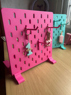 Expositor de mesa rosa con panel perforado y ganchos para exhibir productos